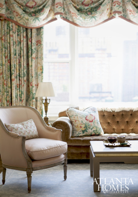 Living room draperies by Brunschwig & Fils add a decorative punch above the Scalamandré velvet tufted sofa.