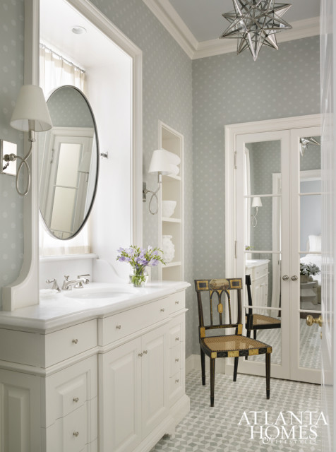 The guest bath features tile and lighting from Waterworks, while a star chandelier from Vaughan echoes the wallpaper by Cowtan & Tout.