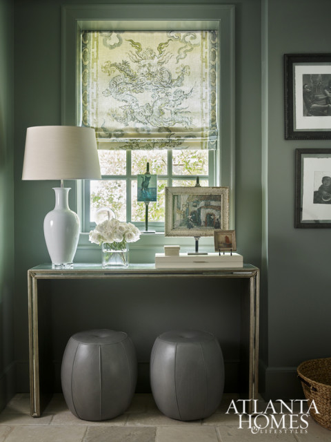 Janie Wilborn wrapped the mudroom in a deep blue-gray hue for a striking effect. An antiqued mirror console and leather stools pull double duty as beautiful accents and—respectively—a place to set down keys and an impromptu stepstool.
