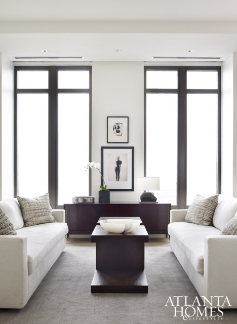 “Balance and repetition was key to this space,” explains Brown, who outfitted the sitting area with dark woods and neutral fabrics. The designer devised the pair of custom cocktail tables, which are bracketed by matching Verellen sofas. Throw pillows are covered in a gray tweed by Lauren Hwang New York.