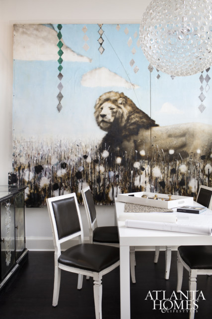 Dining room with a large abstract painting of a lion in a field, white dining table with chairs, and a crystal chandelier.