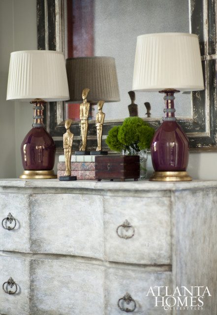 Jessica Bradley continued the formal bathroom’s harmony into the adjoining hallway via gilded sculptures and a distressed chest.