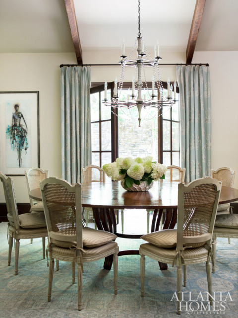 A round table from Ainsworth-Noah serves feels anything but formal thanks to cane-back chairs and French doors.