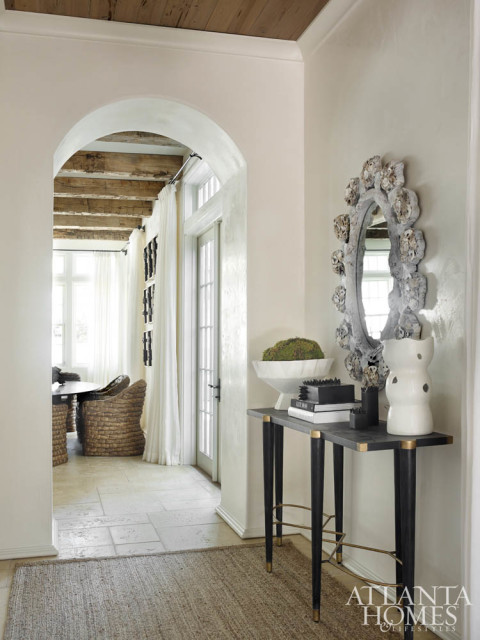 An artful oystershell mirror and a handsome console from Gabby hold court in the foyer.