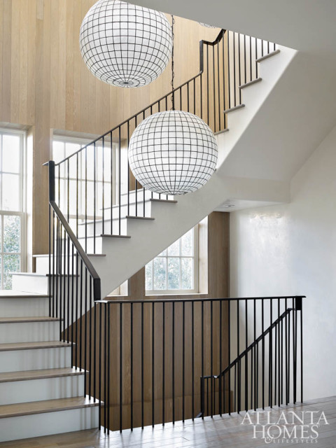 Spherical glass lighting from Restoration Hardware creates a striking focal point on the staircase.