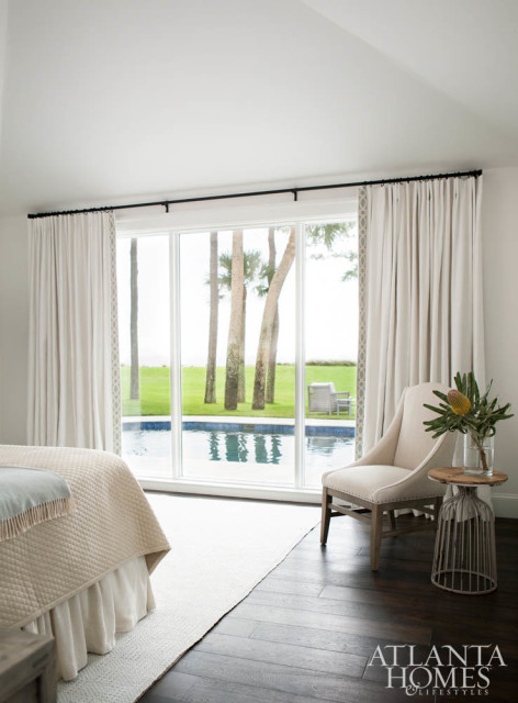 The tranquil ocean suite is accessed via a hidden door in the kitchen that’s disguised as a tall cabinet. It features a rustic table and chair from Taylor House Interiors. The bedding is from Gramercy Home.
