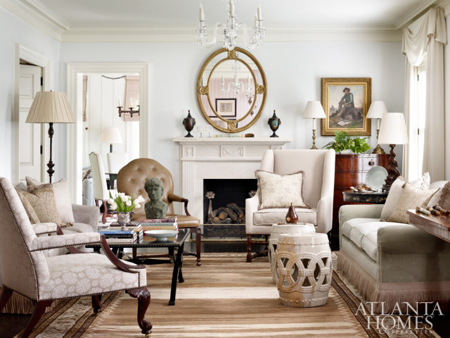 A palette of soft blue, green, creamy white, and brown flows from one room to another, including in the living room, where designer Jackye Lanham uses a mix of European antiques and comfortable upholstery to give the formal space an air of coziness.