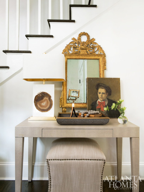 An antique mirror and portrait sourced from the South of France take pride of place in the foyer.