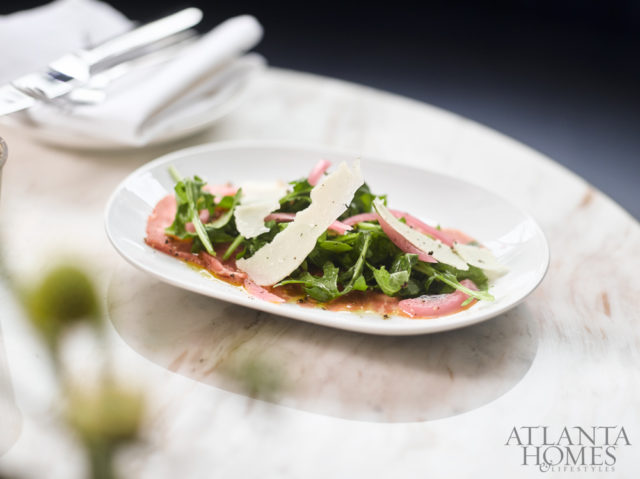 beef carpaccio with arugula, pickled red onion, parmesan, and olive oil.
