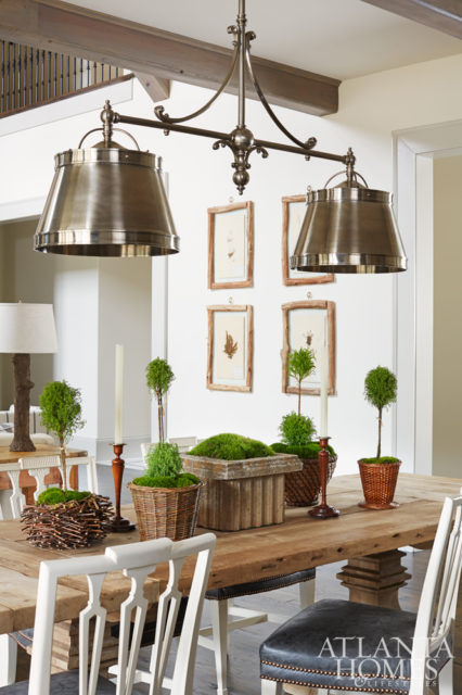 The kitchen, the most popular room in the house, is equipped with a long, family-style dining table and chairs from Restoration Hardware. An industrial double pendant from Visual Comfort adds a hint of masculine texture to the space.