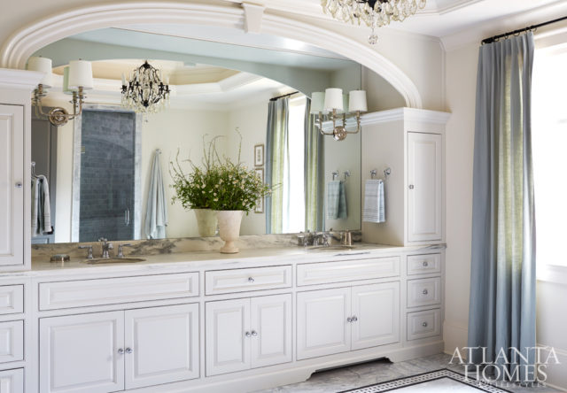 Chris and Karrie requested his and her sinks with an arched frame. Meier sourced a pair of shaded sconces from Progressive Lighting and had them installed directly onto the mirror to help reflect and spread light throughout the room.