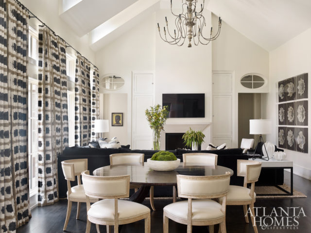 Style meets function in the combination living-dining room of this Buckhead residence by interior designer Melanie Turner and associate Jill Tompkins. To keep the aesthetic masculine, stylish, but also fresh, they began by selecting a bold Scion fabric for the draperies; its pared down color palette influenced the home’s overall design direction. The dining table is by Amy Howard and the Klismos chairs are by Global Views.