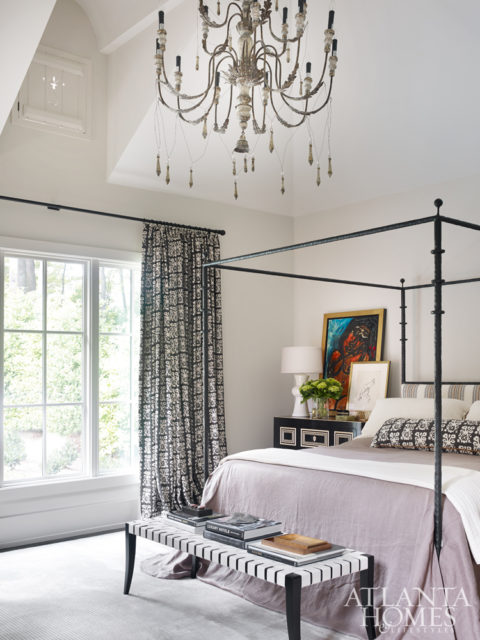 The master bedroom effortlessly mixes traditional and modern styles. The custom bed is by Ironware International; the Neidermaier bench is from Travis & Company.