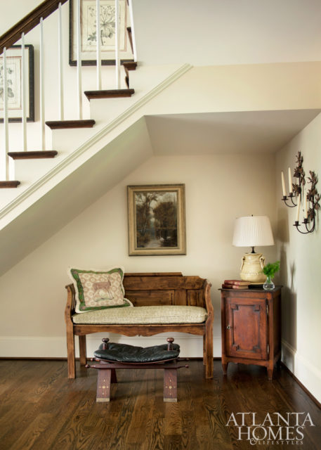 A cozy nook in the foyer also features time-honed treasures, such as an old bench, a French table and a petite leather stool that has served as the “time-out stool” for many generations.