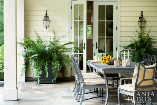 The covered porch, with both dining and living spaces, overlooks a pristine setting cultivated by Alec Michaelides.