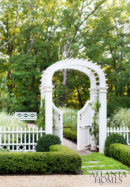 A graceful gated archway offers entrée into the formal perennial garden. The lush backyard was the vision of landscape architect Alec Michaelides, principal of Land Plus Associates.