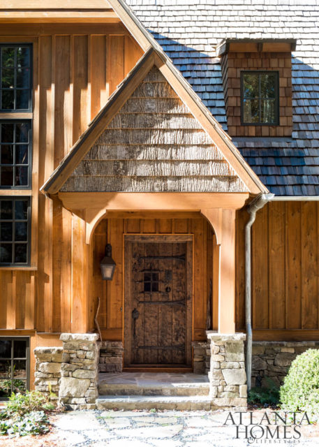 A cedar-shake roof, cypress board-and-batten siding and stacked stones make this home—designed by architect Greg Busch and interior designer Meridy King—look in harmony with the wooded landscape.