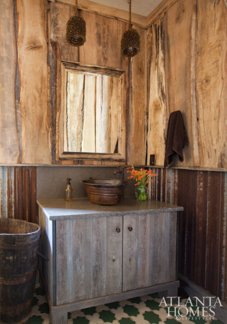 While the home’s rustic atmosphere is present in this bath via corrugated metal wainscoting, it is tempered by a mosaic tile floor.