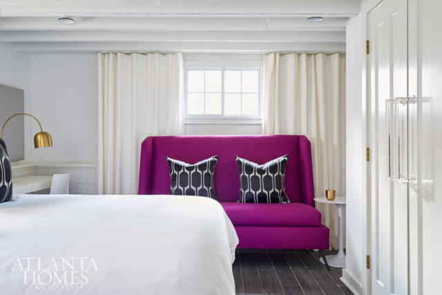 The terrace-level guest room features a magenta sofa from S.O.M. and closets accessorized with oversize acrylic handles that Kay cleverly fashioned from CB2 towel bars.