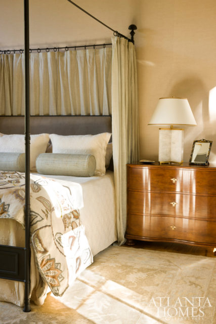 A canopy bed by Madeline Stuart holds court in the master suite. To prevent the expansive space from feeling cold, Ferguson covered the walls with linen to add subtle texture. The custom duvet is made with fabric by Mulberry Home, setting the soothing color palette for the light-drenched room.