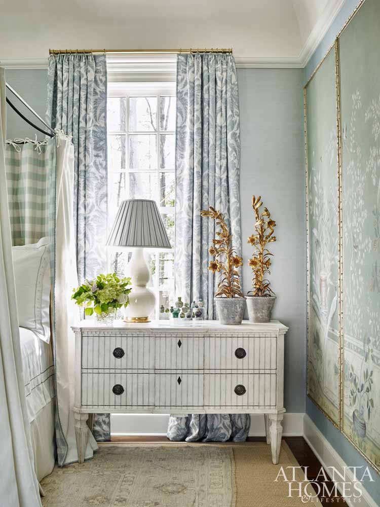 Elegant traditional blue bedroom with painted panels, blue drapes, and brass hardware.