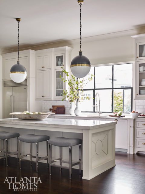 Bernhardt barstools sidle up to a custom countertop by builder Monte Hewett Homes. Visual Comfort pendants add contrast to the white kitchen, while subway tile adds a timeless layer. Cutting boards from Robuck. Montes Doggett pottery from B.D. Jeffries.