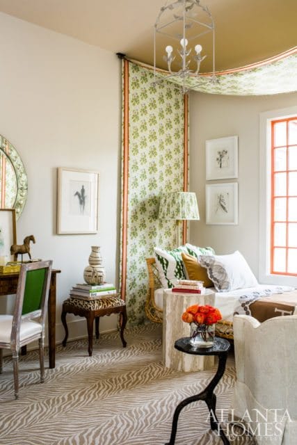 Bedroom with a daybed, patterned green and white curtains, a zebra-print rug, and a desk with a horse figurine.