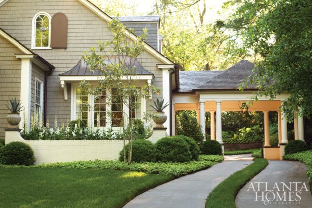 A porte cochère, part of a renovation by architect D. Stanley Dixon, beckons guests to this Buckhead cottage. A grass strip adds an interesting classic detail.
