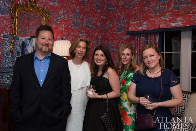 Five people posing for a photo in a room with red and blue toile wallpaper. A logo for Atlanta Homes & Lifestyles is visible in the lower right corner.