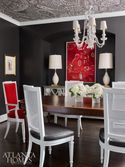 In the dining room, high-impact paisley wallpaper, deep gray walls and bold red flourishes make a statement.