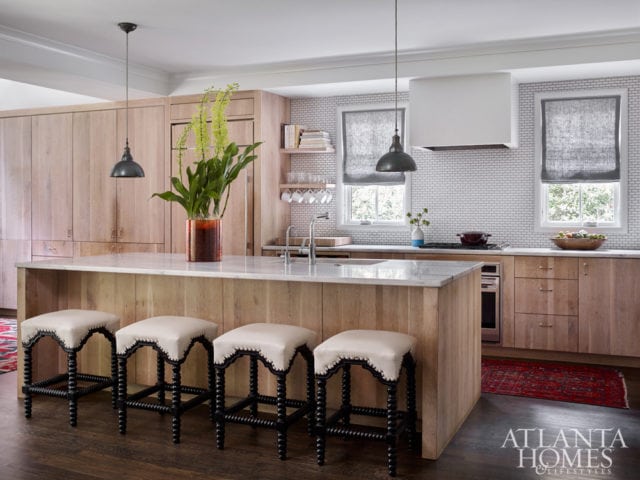 In their kitchen, the couple utilized surplus white oak (lime-washed by frequent collaborator and furniture craftsman Skylar Morgan) for custom cabinetry. Spindle-style stools from Bungalow Classic add a classic element to an island topped with the same local Cherokee marble that their firm, Square Feet Studio, used for countertops at West Egg Café and The General Muir.