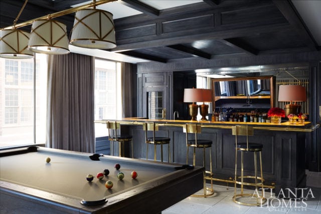 The home’s overall lighthearted look takes a turn in the bar and billiards space with an illuminated onyx bar top. “It’s a nighttime room, so we used a dark gray for the bar area,” says Turner. An antique mirror and shapely lamps temper the room’s masculine feel.