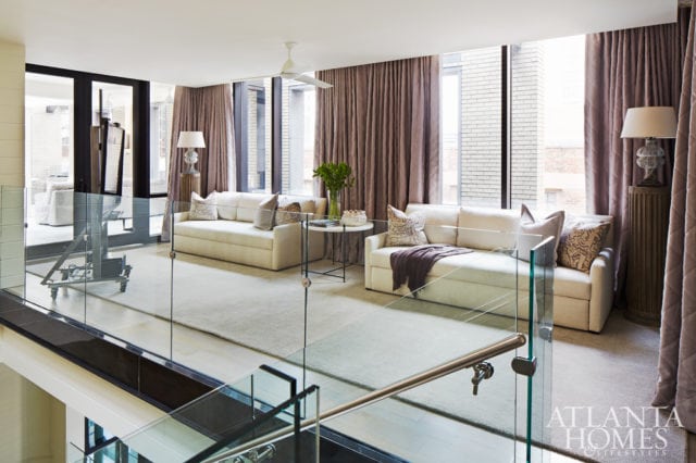 A landing area on the top floor pulls double duty with a pair of Lee Industry sofas (through UpCountry Home) that convert to guest beds. The drapery fabric is Kravet.