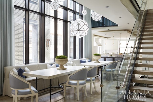 A pair of tables by Bradley and generous, cleverly designed slip-covered banquettes make entertaining crowds a breeze in this light-filled dining room that’s adjacent to the kitchen. The dining chairs are Oly Studio and the bar stools are Bradley.