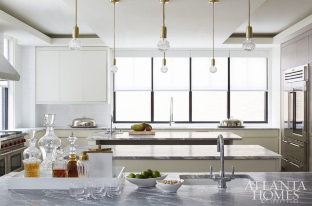 The townhouse kitchen features three islands—one of which is a bar—so food can be prepared en masse while others enjoy the action (or the fruits of their labor). The hand-cut crystal bulb pendants are by Lee Broom.