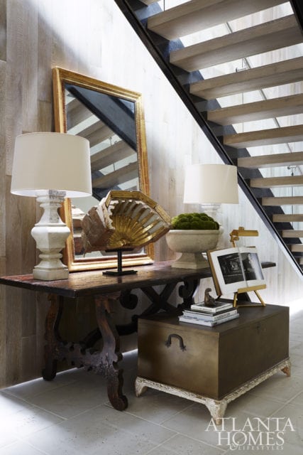 Antiques, such as the trunk from Tara Shaw, soften the home’s modern edges. The planter is Elegant Earth.