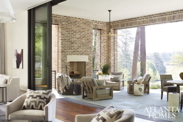 A NanaWall glass wall system opens up to create a sprawling indoor-outdoor space with magnificent vistas of the neighboring golf course. An electronic Lutron shade rolls down for privacy or insect control, while teak furnishings from Restoration Hardware and concrete stools from McGuire Furniture create a comfortable arrangement near the outdoor fireplace.
