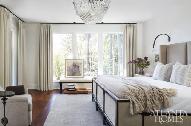 In the master bedroom, a crystal chandelier echoes the lines in the tailored wool draperies, which are a Holland & Sherry fabric.