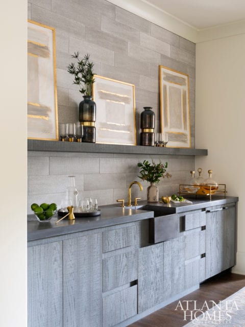 In the farmhouse-inspired kitchen, a trio of Palecek counter stools sidles up to an island anchored by bleached white oak, while stainless steel accents—a simple hood and a pair of coordinating pendants (Circa Lighting’s Fulton style in Industrial Steel)—offer a utilitarian feel. The floral fabric used for the drapery panels is a Kerry Joyce design, and the natural-fiber pendant over the breakfast table is the Amani Drum from Made Goods.