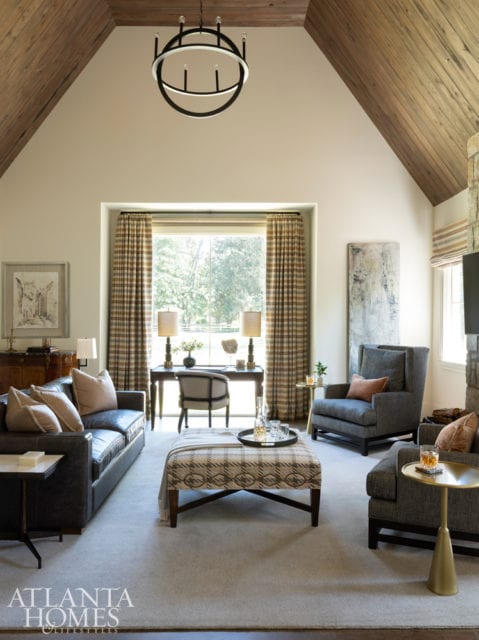 In the man of the home’s tailored study, Bradley selected Zimmer+Rohde drapery panels, Moss Studio armchairs and a leather Lee Industries sofa. The brass drinks table is by Noir.