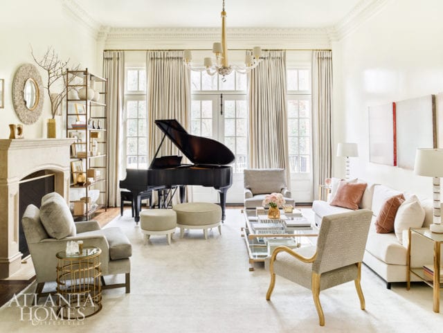 A soft rug and high-gloss paint create a bright, light backdrop for a custom sofa in silk velvet by Christian Liaigre, brass accent tables, a gilded chair and the owner’s piano.