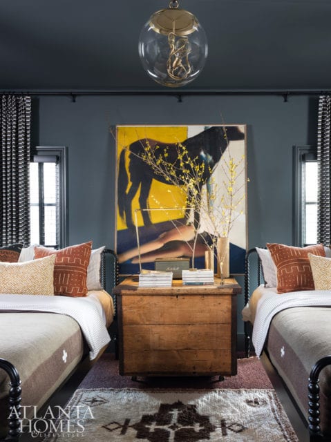 To provide his guests the ultimate in comfort, Hughes combined two small bedrooms to make a single, immense one. An antique pine trunk is tucked between the two Jenny Lind beds from Crate & Barrel. The reproduction wool military blankets are BoBo Intriguing Objects.