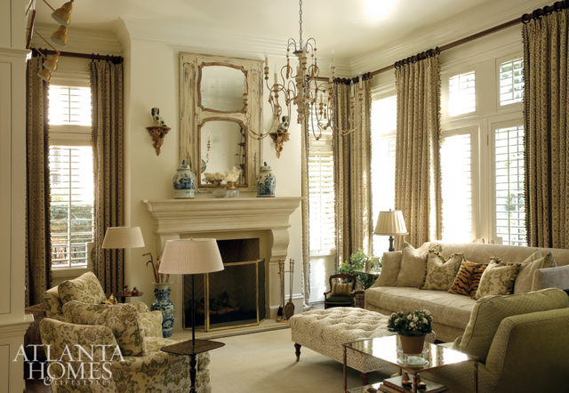The living room is equal parts inviting and chic. Here, a subtle Suzanne Tucker floral covers a pair of tight-back armchairs, and reappears once more on accent pillows on the sofa. The Vaughan chandelier is from Ainsworth-Noah. The 19th-century trumeau mirror and a number of accessories from House of Hazen make for perfect conversation pieces.