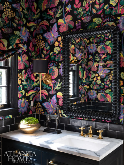 Inspired by the existing vintage yellow-and- black floor tile, Turner outfitted the guest bathroom with painted cabinetry by Karpaty, black subway tile from Source, LLC, and a mirror by Noir. The wallcovering is by Schumacher.