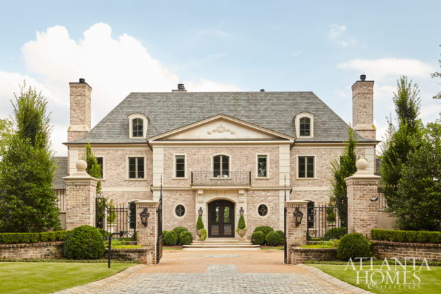 A commanding wrought iron and painted gold fence by Lipko Iron Works blends with a cast limestone fountain and sand-cast brick in the backyard.