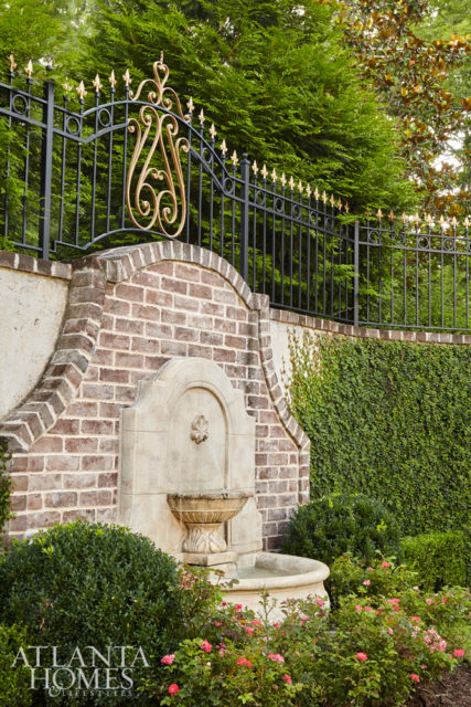 The Harrison Design team elevated the scale of the entry with two larger tiers topped with limestone ball finials that convey the home’s ornamental and grandiose feel.