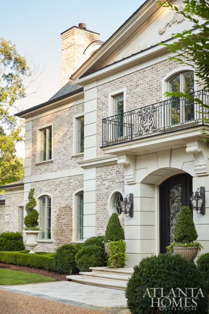 This neoclassical French home by Harrison Design radiates a stately presence with materials that include limestone, wrought iron, stucco, sand-cast brick and cobblestone. The builder and general contractor was Brody Dernehl with The Dernehl Company.