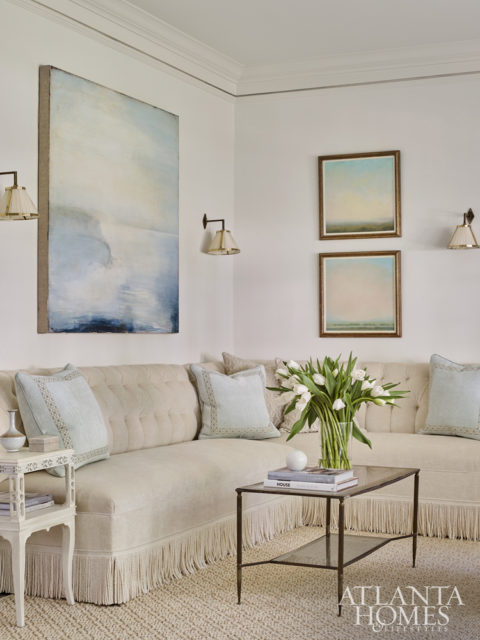 A banquette with bullion fringe adds formal flair. The art is by Shawn Dulaney and Michael Abrams, both through Sears Peyton Gallery.