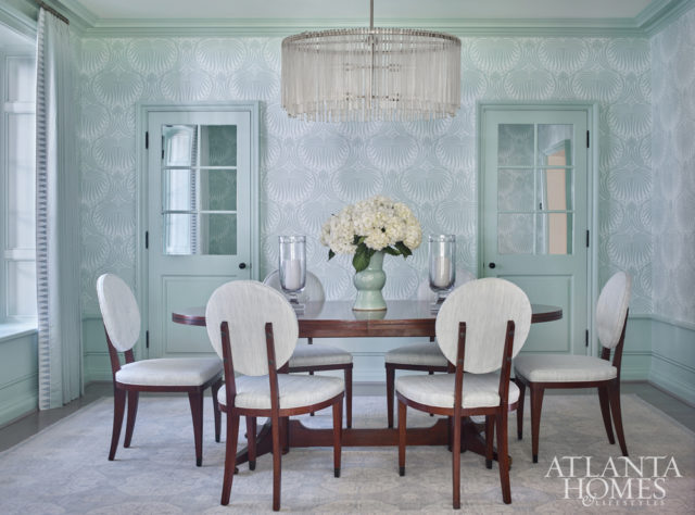 Farrow & Ball’s Lotus wallpaper serves as the foundation for the bold yet understated dining room. Century Furniture dining chairs, upholstered in Downey by Christopher Farr Cloth, sidle up to a classic-meets-modern dining table by Mr. and Mrs. Howard for Sherrill Furniture. The chandelier is by Arteriors.