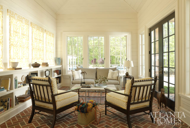 Located right off the kitchen, the sunroom plays up the home’s farmhouse aesthetic with traditional brick pavers and wood planking. The chairs are by Stanford Furniture and feature a Pearson Textiles fabric.